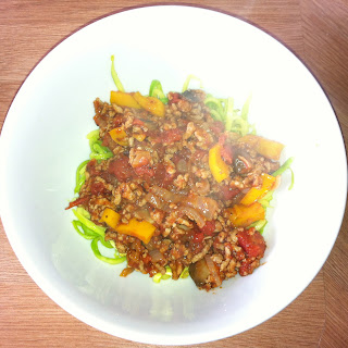 wheat free pork bolognese in a white bowl - steaming hot