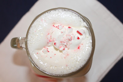 Crushed candy canes on tip of a mug of peppermint white hot chocolate.