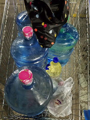 five gallon plastic bottles of water in a shopping cart