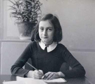 Anne Frank at a desk. Thirteen in 13 campaign