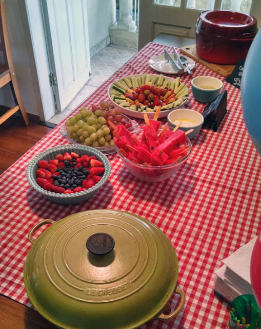 Mãe dando a seus filhos tábua de madeira com lanche vegetariano vegano