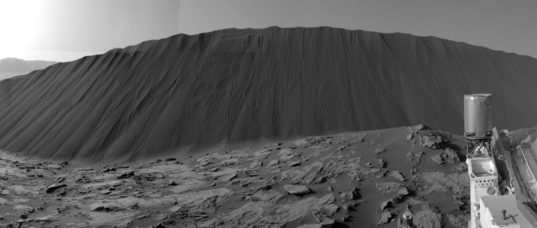 Khung cảnh này từ đôi mắt của tàu tự hành Curiosity được chụp khi nó đứng bên dưới Đồi cát Namib cao 4 mét. Khu vực này là một phần của Đồi cát Dunes lớn hơn, tạo thành một dải cát tối màu chạy dọc theo sườn phía tây bắc của Núi Sharp. Hình ảnh này cũng được ghép lại từ những hình ảnh nhỏ hơn để tạo ra ảnh toàn cảnh góc rộng, được chụp vào ngày 17 tháng 12 năm 2015, nhằm sol 1196. Hình ảnh: JPL-Caltech/MSSS/NASA. Khung cảnh này từ đôi mắt của tàu tự hành Curiosity được chụp khi nó đứng bên dưới Đồi cát Namib cao 4 mét. Khu vực này là một phần của Đồi cát Dunes lớn hơn, tạo thành một dải cát tối màu chạy dọc theo sườn phía tây bắc của Núi Sharp. Hình ảnh này cũng được ghép lại từ những hình ảnh nhỏ hơn để tạo ra ảnh toàn cảnh góc rộng, được chụp vào ngày 17 tháng 12 năm 2015, nhằm sol 1196. Hình ảnh: JPL-Caltech/MSSS/NASA.