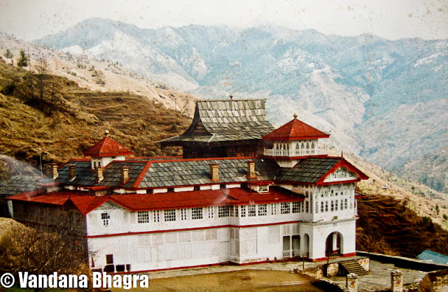 An architectural marvel: Jubbal Palace : By Shimla, Vandana Bhagra : Photo credits: Given by the owners : When we use the phrase “har ghar kuchh kehta hai”, a novel concept adopted by the Himachal government in promoting heritage properties of Shimla town, we often associate them with the Britisher’s rule, rich in history with facts, photographs and antiques dating back to that period. And when we talk about royalty we are equally impressed by the grandeur and imperial finesse with which they once lived in or are still living. One such architectural marvel is the Jubbal Palace, residence of HH Raja Rana Yogendra Chandra and Rani Sudha Kumari, about 92 kms from Shimla taking approximately four hours to reach via Theog, Kotkhai and Khara Patther. The setting is just picture perfect, with River Bishkalti on one side and the Kuper peak as the backdrop. Once described in the Imperial Gazetteer of India as being “built in partially Chinese style, the lower portion consisting of masonry, while the upper half is rined round with wooden galleries capped by overhanging eaves. The Palace is remarkable for the enormous masses of deodar timber used in its construction”. Rightly said, as when you walk through the Durbar Hall or the Indian style baithak your steps are arrested by the massive paneling work done on the ceilings, the intricate woodwork, carved bordered facades, Persian carpets and antiques all around the rooms are enough to give you a royal feel. The Durbar Hall has these carved jharokhas on the upper floor, then used by women to watch the proceedings below or the royal functions which were held during those days, were initially built by a women craftsmen from Chaupal and even till date they remain as pristine as ever. As royalty would have it, there were different drawing rooms for both men and women and as Raja Yogendra Chandra adds, “even Raja and Rni had separate bedrooms connected with a spiral staircase”. Family heirlooms which can be seen are quivers and arrows, family portraits, pieces of art and ivory ilaid peacock chairs. The stunning display of ancient artilleries ranging from cannons, swords to muskets and shield will just tickle your senses and give you a feeling of being a warrior. The fireplaces add an old charm to the Palace which has a collection of Kangra paintings on the Radha Krishna theme hung over them.  The old structure was brought down in 1935 and what stands now is a mix of Gothic, Art Deco and local architecture. An interesting anecdote Sudha Kumari states “It was decided that a new Capital would be built for administrative purposes, which would have a new Palace, a tehsil, a prison and an armoury and Old Jubbal would only be used for religious functions and on these grounds a pujan was performed during which as a ritual a chicken was sacrificed. The place where this chicken would land would be earmarked as the new location of the Palace. The bird landed on a small hill formerly known as Deora, now Jubbal, where construction began”. Despite the fact that a French architect was hired to dothe initial structure but Rani Sudha, soon after marriage in 1960, involved herself with the construction of the Palace and personally saw to it that the esthetics of the place was maintained. The modern wing of the Palace exhibits an inquisitive blend of Indo and European styles. Even after the Sheesh Mahal and three other buildings in the Palace complex were burnt down on 29th October 1969, she ensured that same style was adopted while reconstructing the building. The Sheesh Mahal was adorned with large framed mirrors with all modern facilities, the construction of which was started by Raja Sir Bhagat Chandra of Jubbal in 1911 and was completed in 1918.  Whereas the present Palace was built by his son Raja Digvijai Chandra and the construction was started in 1935. Raja Yogendra Chandra, adds “construction of buildings, prior to the making of Sheeh Mahal during those days, was done without using any iron nails as only wooden pegs were used to hold thestructure. Layers were made of stone and wooden beams whih held the structure firmly and resistant to earthquakes or tremors. While undertaking construction of the new sections these concepts were kept in mind”. The entrance of the Palace opens into the central courtyard where a temple stands tall with a Pagoda style roof and a unique feature as lead has been used in its construction. Nestled behind the temple tower is the oldest wing of the Palace built in Pahari-style with alternate courses of dressed stone and wooden beams. There are numerous numbers of bedrooms with attached bathrooms, built around the courtyard, furnished with Persian carpets, amazing accessories and beautifully carved furniture. The umpteen number of artifacts and family treasures discovered in the old wing of the Palace have been restored and displayed all over the Palace by Sudha, who spends nearly four months in a year at Jubbal.  Rani Sudha says, “a section of the property was opened to guests but since the courtyard was common and our private quarters were in the same area we felt that ur privacy was being disturbed. In spite of the fact that we were overbooked, we decided to close the property for guests just after a month. Communication too was a huge problem due to bad road conditions”. Admiringly Yogendra Chandra says, that the upkeep and maintenance of the Palace is credited to my wife and son who look after the place as its fresh paintwork, polished woodwork round the clock, sparkling windowpanes and glistering balconies are a thing to fathom. The upcoming library section is a welcome addition to their Palace as it holds a treasure of books collected over a period of time. Rani Sudha reminisces and ends on a note on how Jubbal earned its name, “one day a person was seen digging and planting seeds, and second day a joob (evergreen grass) came up, or dhub, used on auspicious occasions, and he called it as a good omen saying that there would be everlasting greenery and prosperity, and the Raja, who was then staying in Raika, near Hatkoti, should build his Palace here. Hence, this place arned its name as Jubbal”.