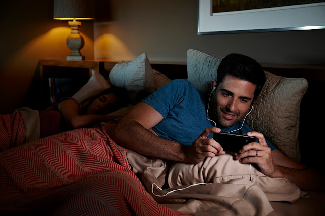 couple bed bingewatching netflix smartphone