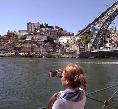 mulher a tirar uma foto do Porto com o celular