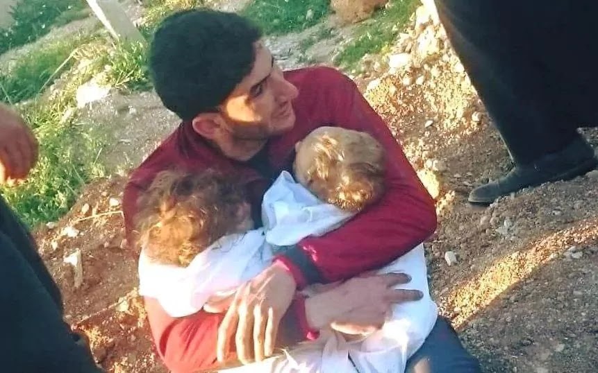 Abdulhamid Yussef cradles his twins Aya and Ahmad before they are buried in Idlib following a Sarin gas attack CREDIT: ALAA AL-YOUSSEF 