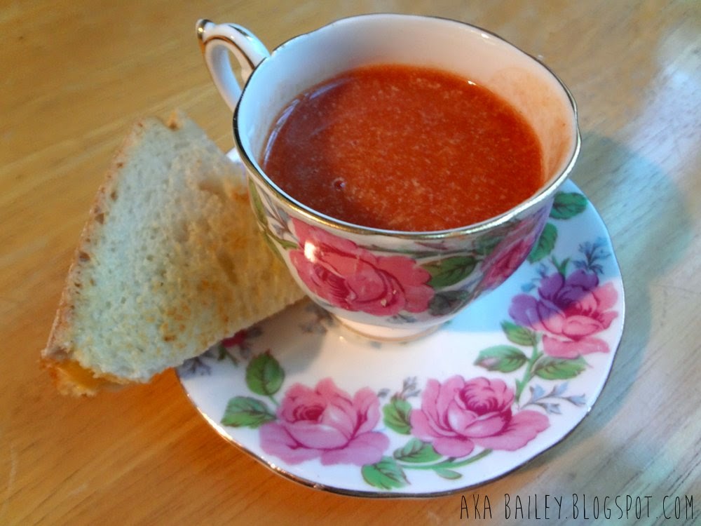 Tomato bisque and grilled cheese wedge, served on a teacup