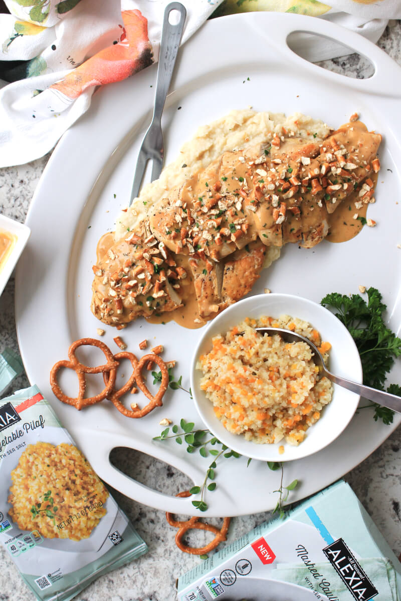 Mustard Cheddar Chicken is an easy skillet dinner that features pan-seared chicken covered in a cheesy mustard herb sauce and topped with crushed pretzels. Serve with Alexia Premium Vegetables for a complete meal that's made in under 30 minutes! #AlexiaVeggieSides #ad @AlexiaFoods #easydinner #skilletrecipe #maindish #chickenrecipes
