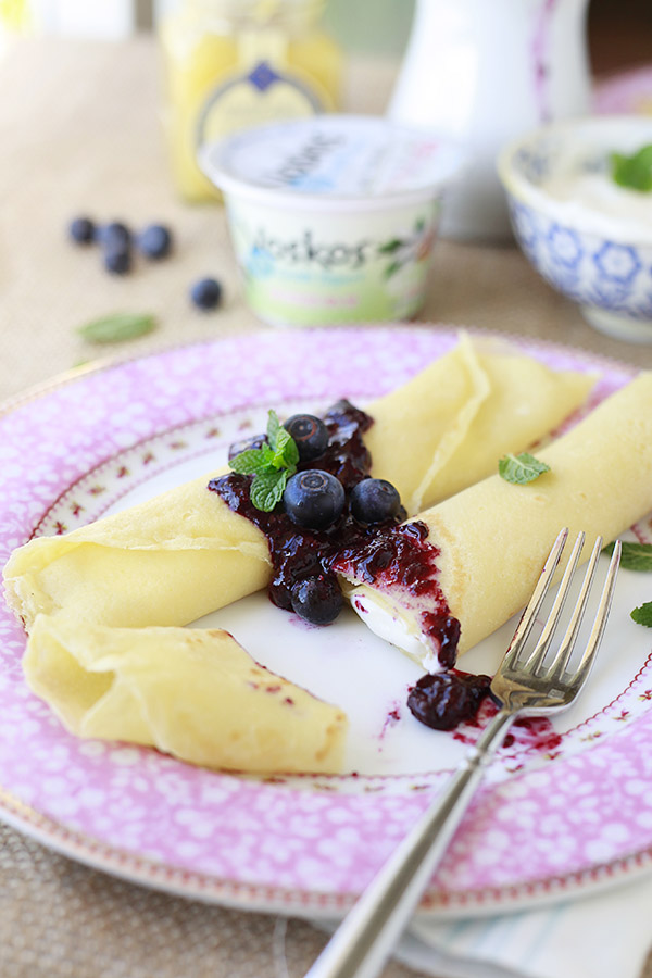Lemon Filled Crepes with Blueberry Sauce Beautiful plate of crepes filled with creamy lemon filling and topped with fresh blueberry sauce.