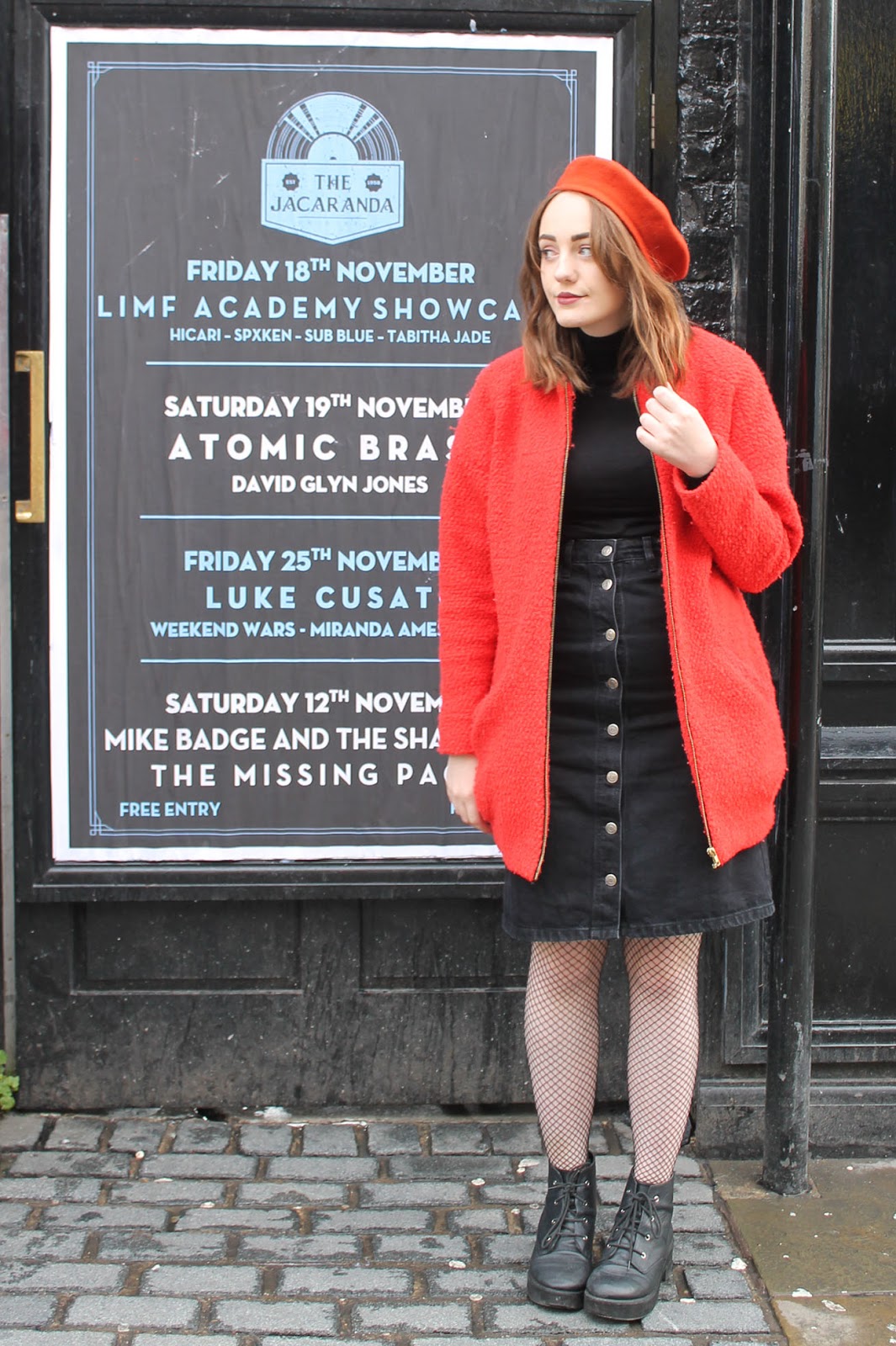 60s inspired outfit including orange Mary Quant beret, black polo neck jumper, black denim button up midi skirt, orange boucle pea coat, fishnet tights and black lace up boots