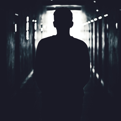Black and white photo of a silhouette of a man in a tunnel