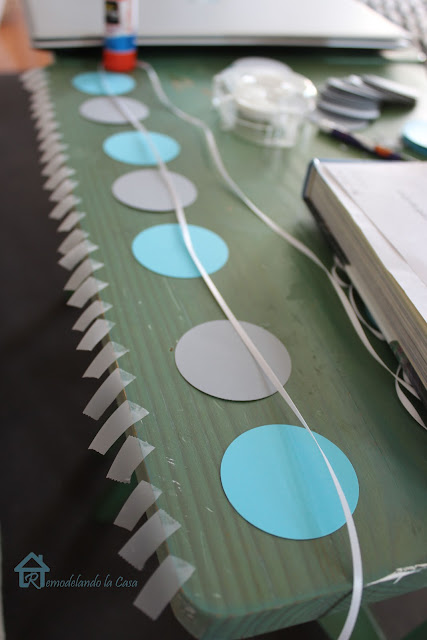 blue and grey paper circles and many pieces of tape to create Christmas garland.