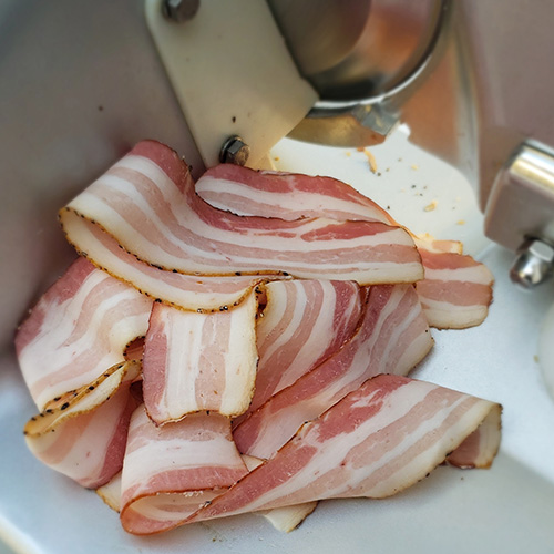 Thin sliced bacon on a Beswood 250 slicer.