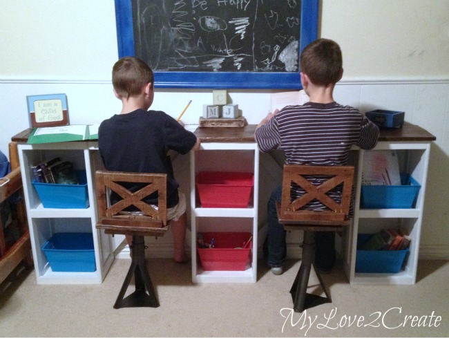kids sitting at the desk trying out chairs