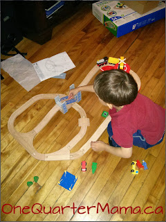 Little Man playing with Imaginarium train set OneQuarterMama.ca