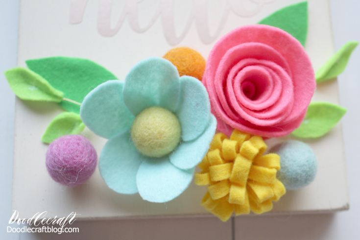 Step 7: Felt Flower Arrangement Arrange the gorgeous felt flowers however you like.  Add a few more felt balls on it.  Hot glue the wires under the flowers so the leaves peek up a little.  Once you've laid it out the way you like it, hot glue each individual piece in place.