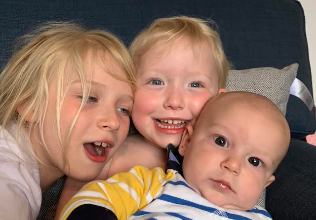 three siblings cuddled together for the camera