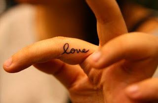 Tatuaje pequeño de flor de palabra "love"