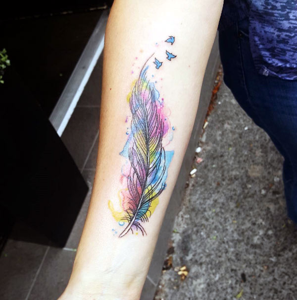This is a delicate and pretty watercolor feather tattoo with birds flying out, that's really so beautiful tattoo designs
