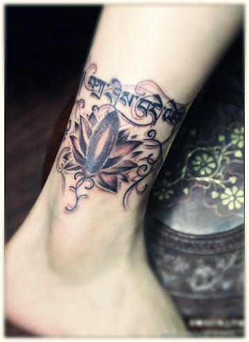 A well designed lotus flower tattoo along with some sanskrit characters