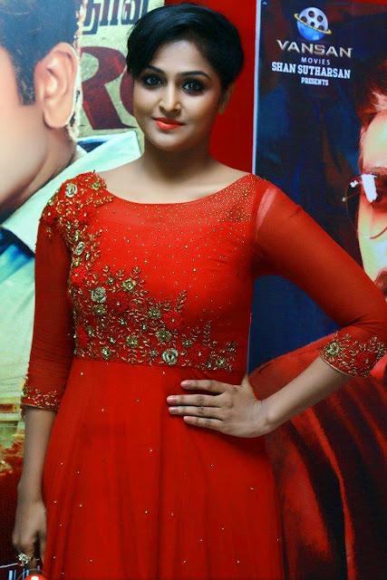 HEROINE REMYA NAMBEESAN IN LONG RED DRESS AND STANDING A RED BACKGROUND VIEW IMAGES Navel Queens