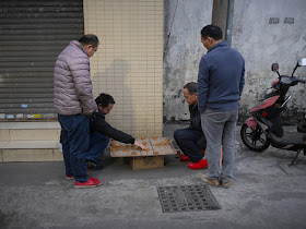 men playing a game of xiangqi on Mazhou Street (麻洲街) in Zhongshan, China