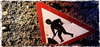 Construction sign shows man digging hole