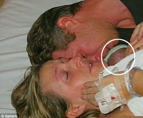 Kate and David clasp each other and their son Jamie, circled, after being told he did not survive the birth. 