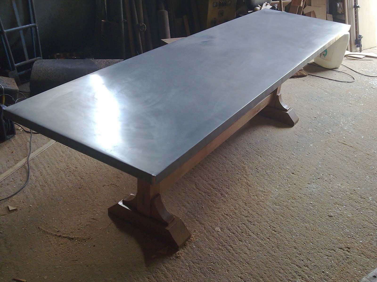 Deballage Designs Oak based trestle table with a burnished zinc top