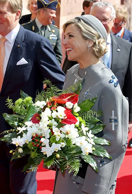 King Willem-Alexander and Queen Maxima of the Netherlands cross the Townhall square