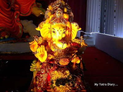 Ganpati idol  in Mumbai Pandal decorated with coconuts, fruits and flowers