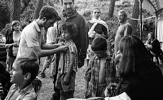 Groupe d'enfants et d'adultes le matin pendant les préparatifs du tournage, maquillage, habillage, pose de micro. La costumière et le réalisateur sont présents.