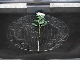 flower on top of an engraving of the Earth