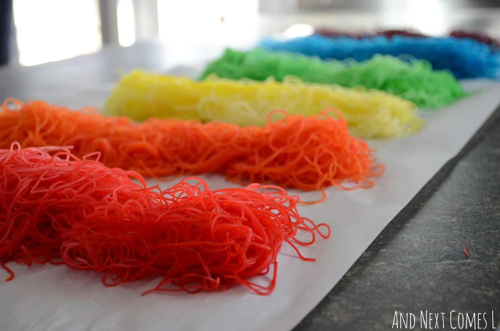 Rainbow dyed rice noodles for sensory play from And Next Comes L