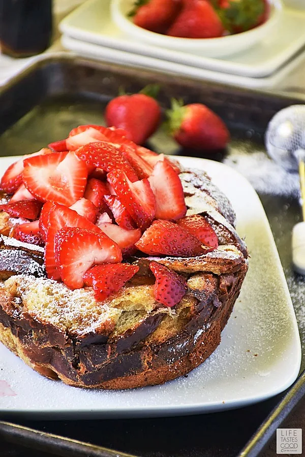 Slow Cooker French Toast dusted with powdered sugar and topped with fresh strawberry slices