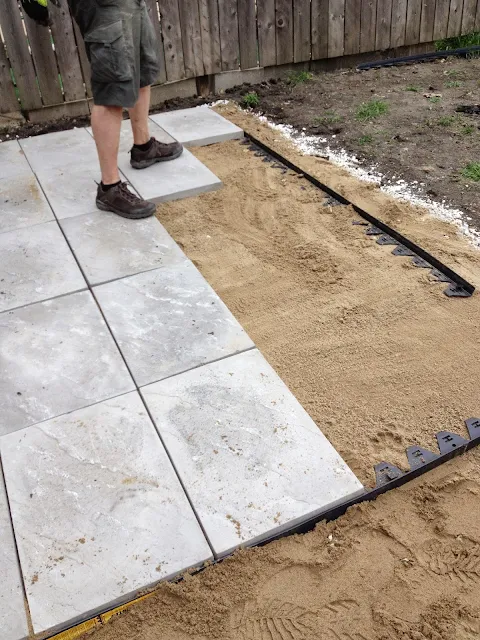 sand atop paver base and adding pavers