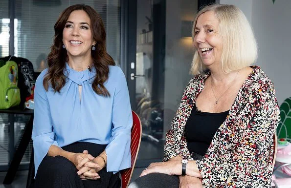 Crown Princess Mary wore Victoria Beckham flare sleeve knot blouse, and pleated midi skirt. Ole Lynggaard Frost earrings