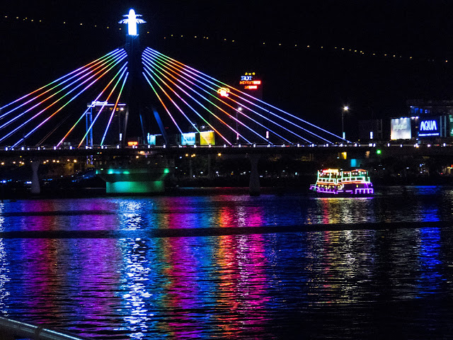 Neon-lighted bridge and boat in Danang Vietnam