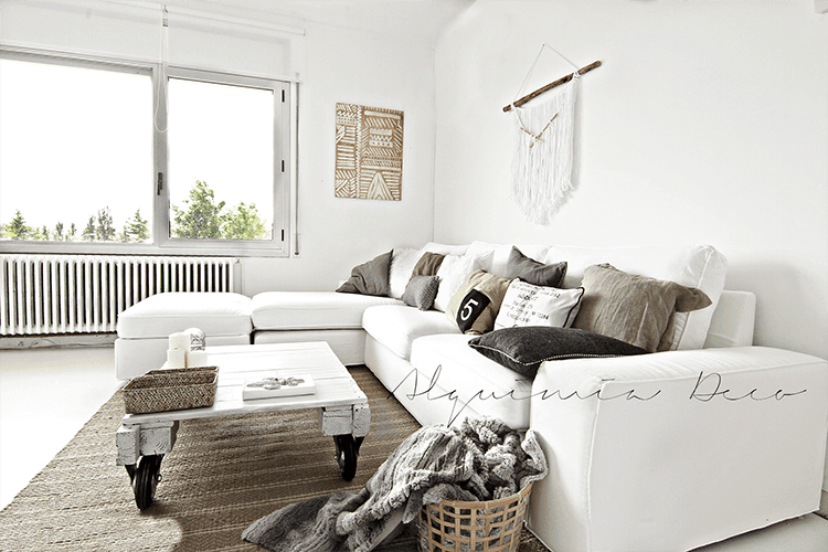 salón con sofá blanco y cojines en beige y gris