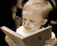 Niño con anteojos leyendo un libro
