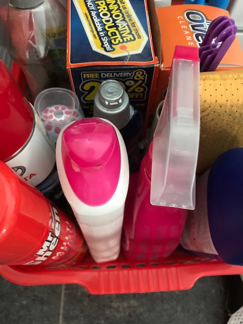 A plastic basket containing cleaning items