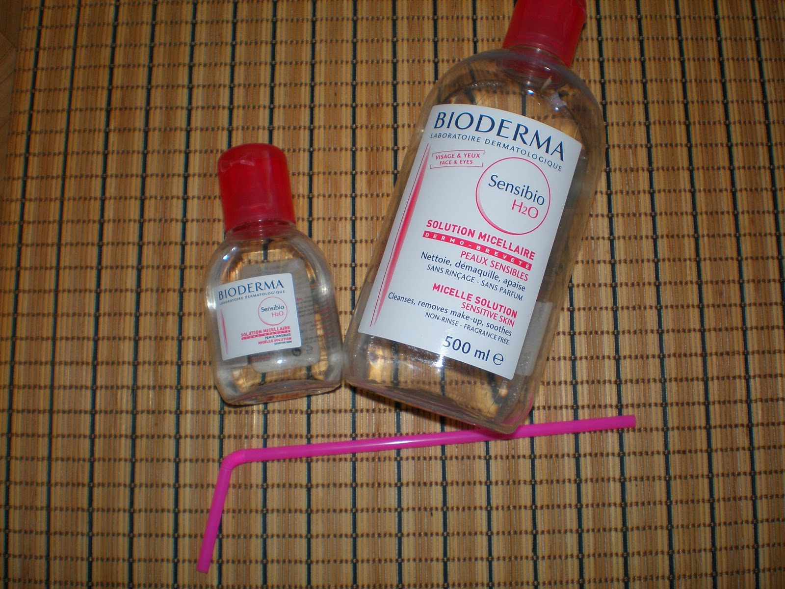 Large and small bottle of Bioderma and a straw