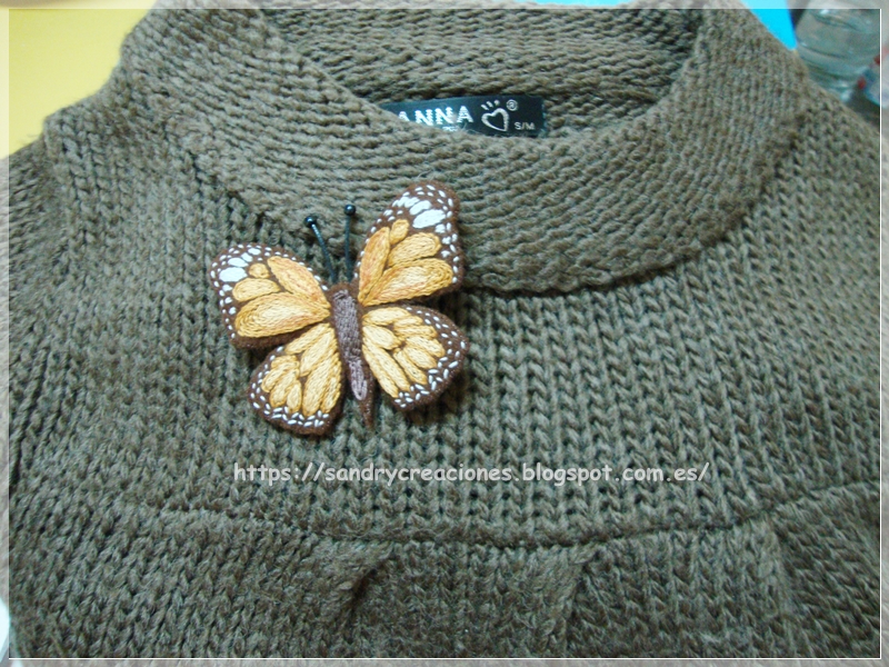 ejemplo de colocación del broche mariposa marrón en un jersey de lana