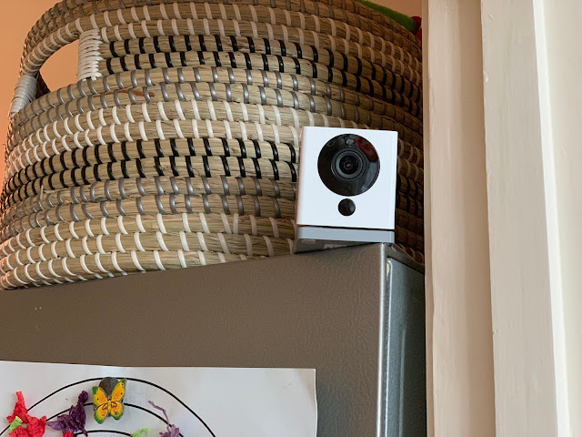 The small Neos SmartCam Indoor Security Camera on top of a fridge being reviewed