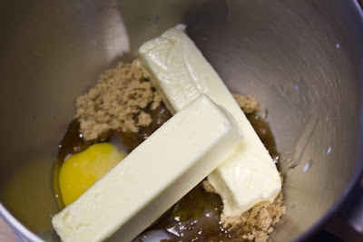 A mixing bowl filled with butter, eggs and brown sugar