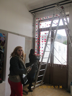 Dos profes del grupo de murales preparando la cortina del amor.