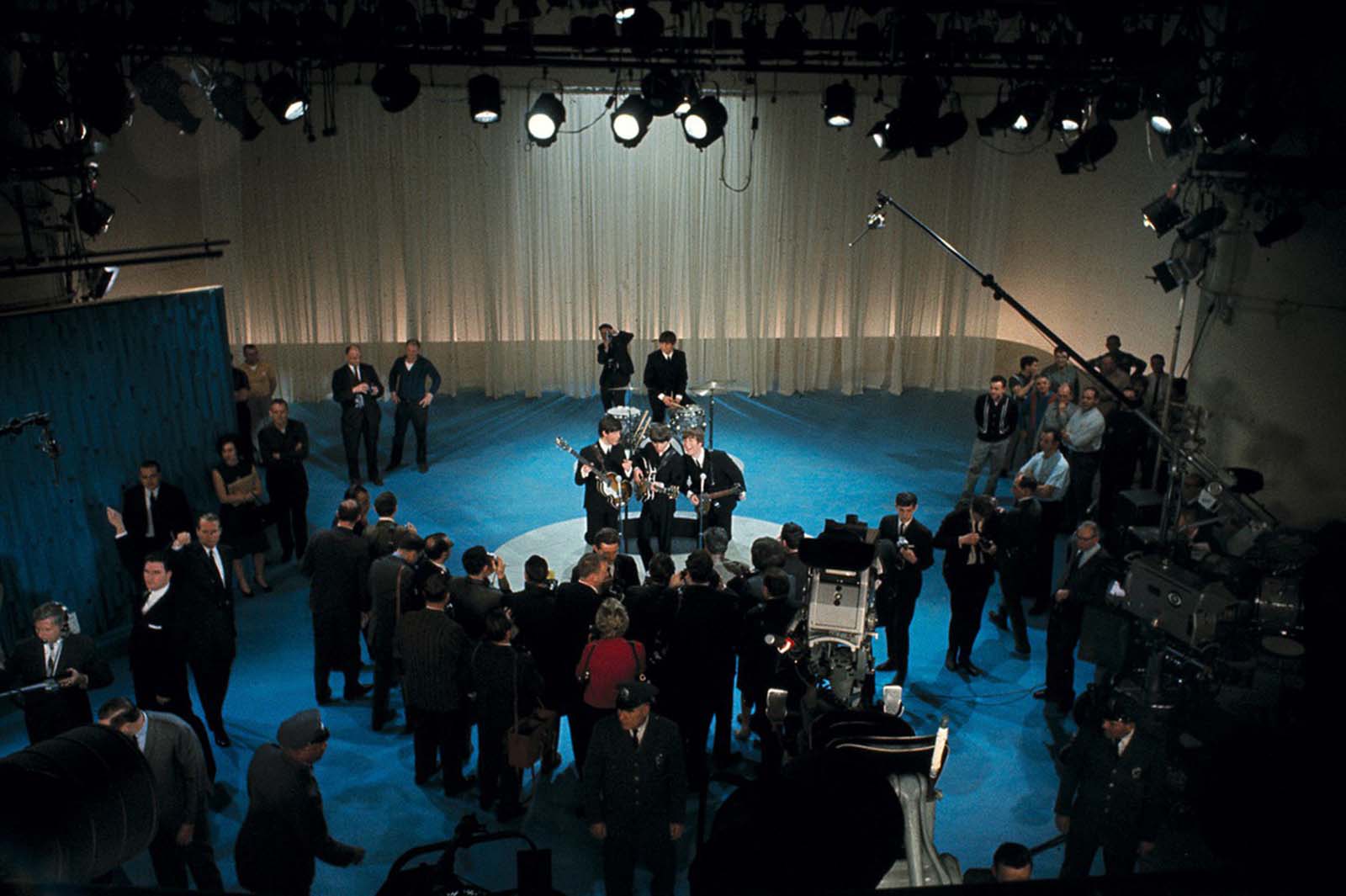 The British rock and roll group the Beatles are surrounded by photographers on stage at CBS' Studio 50 before their live television appearance on The Ed Sullivan Show in New York City on February 9, 1964.