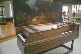   Two side piano with an oil painting scene on the inside cover!  Musikumstrumenten-Museum 