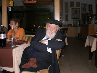 Professor Feuerstein sorride seduto a tavola assieme a Jael Kopciowski