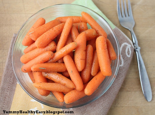 Big bowl of cooked carrots with a fork next to it.